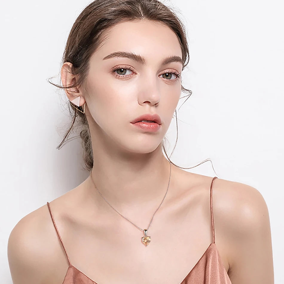 A model wearing the Amber Sunset heart necklace, highlighting its warm orange cubic zirconia pendant on a delicate silver chain.