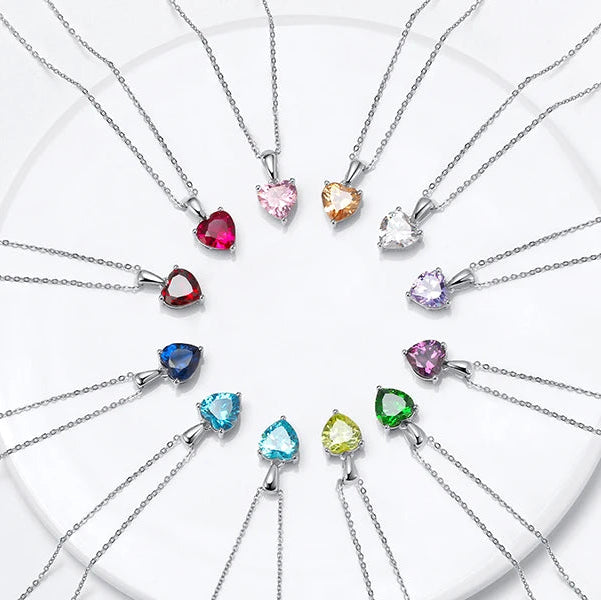 A beautifully arranged display of all birthstone heart necklaces, showcasing their vibrant gemstone colors.