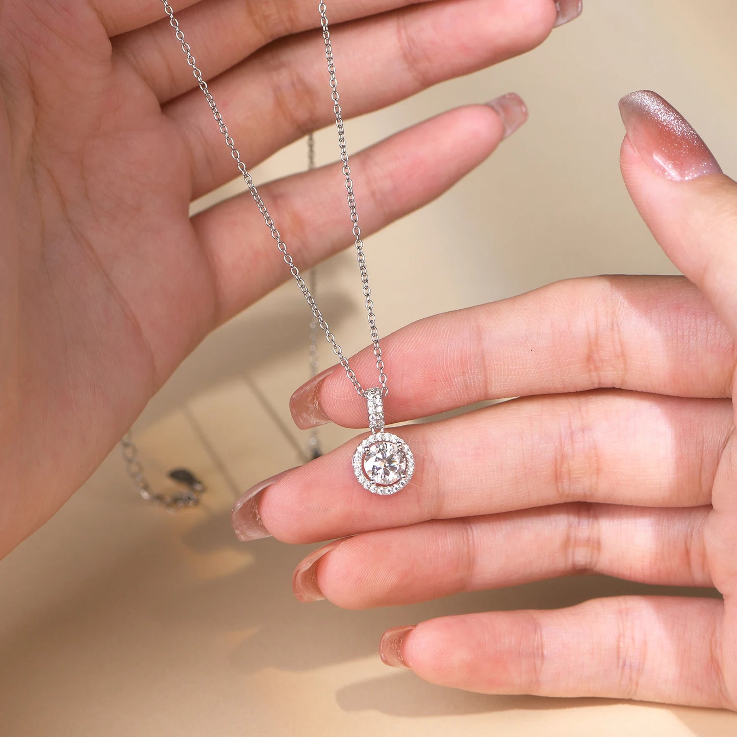 Dainty silver halo necklace with a brilliant round moissanite centerpiece and shimmering accents.