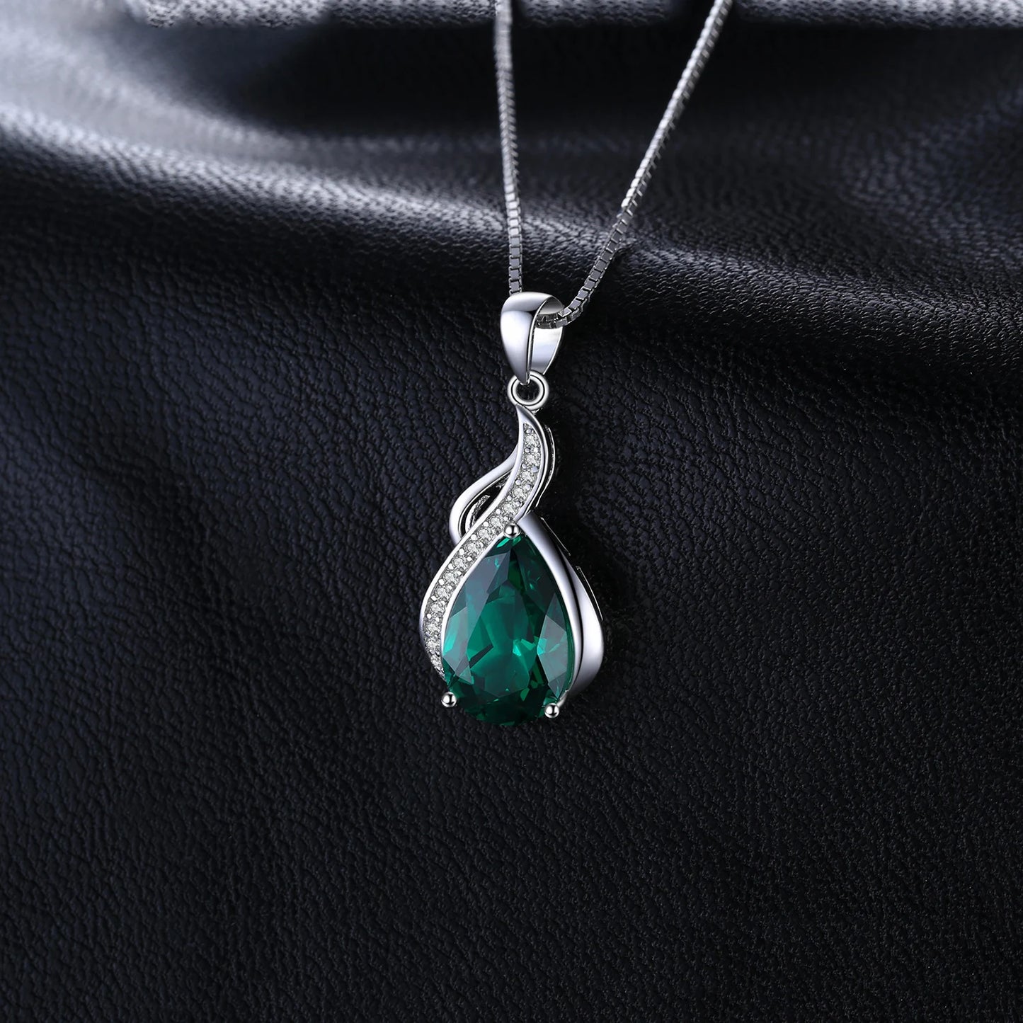 A detailed look at the Emerald Dewdrop Silver Pendant, capturing the shimmer of the cubic zirconia and the rich hue of the simulated emerald.