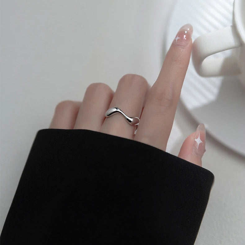 Model's hand showcasing the elegant silver Golden Wave Stackable Ring, adjustable for the perfect fit.