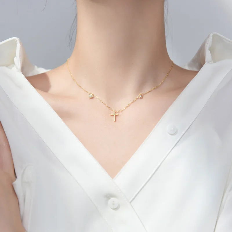A model wearing the Luminous Cross Gold Necklace, capturing the warm glow of 18K gold plating and sparkling cubic zirconia.