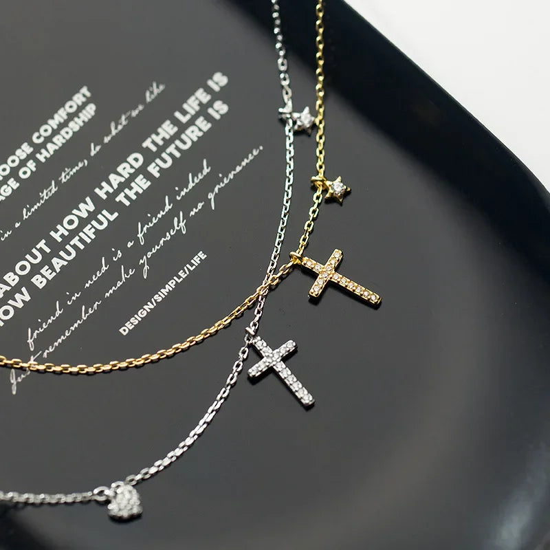 The Luminous Cross Necklace in sterling silver, displayed on a black background to emphasize its intricate cubic zirconia details.
