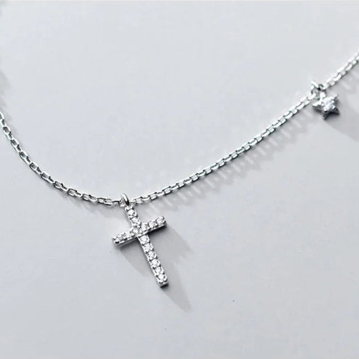 A detailed view of the Luminous Cross Necklace charms in silver, showcasing the brilliance of its cubic zirconia stones.