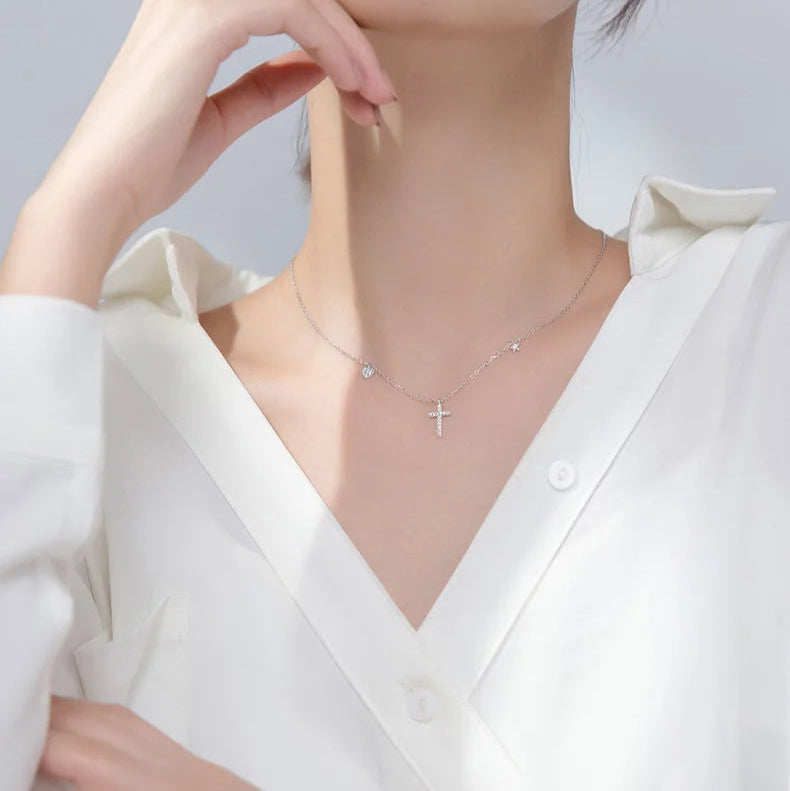 A model wearing the Luminous Cross Silver Necklace with cubic zirconia charms, showcasing its elegant shine.