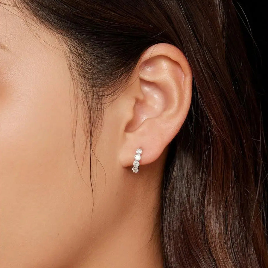 Elegant silver huggie hoops with moissanite stones, perfect for everyday wear.