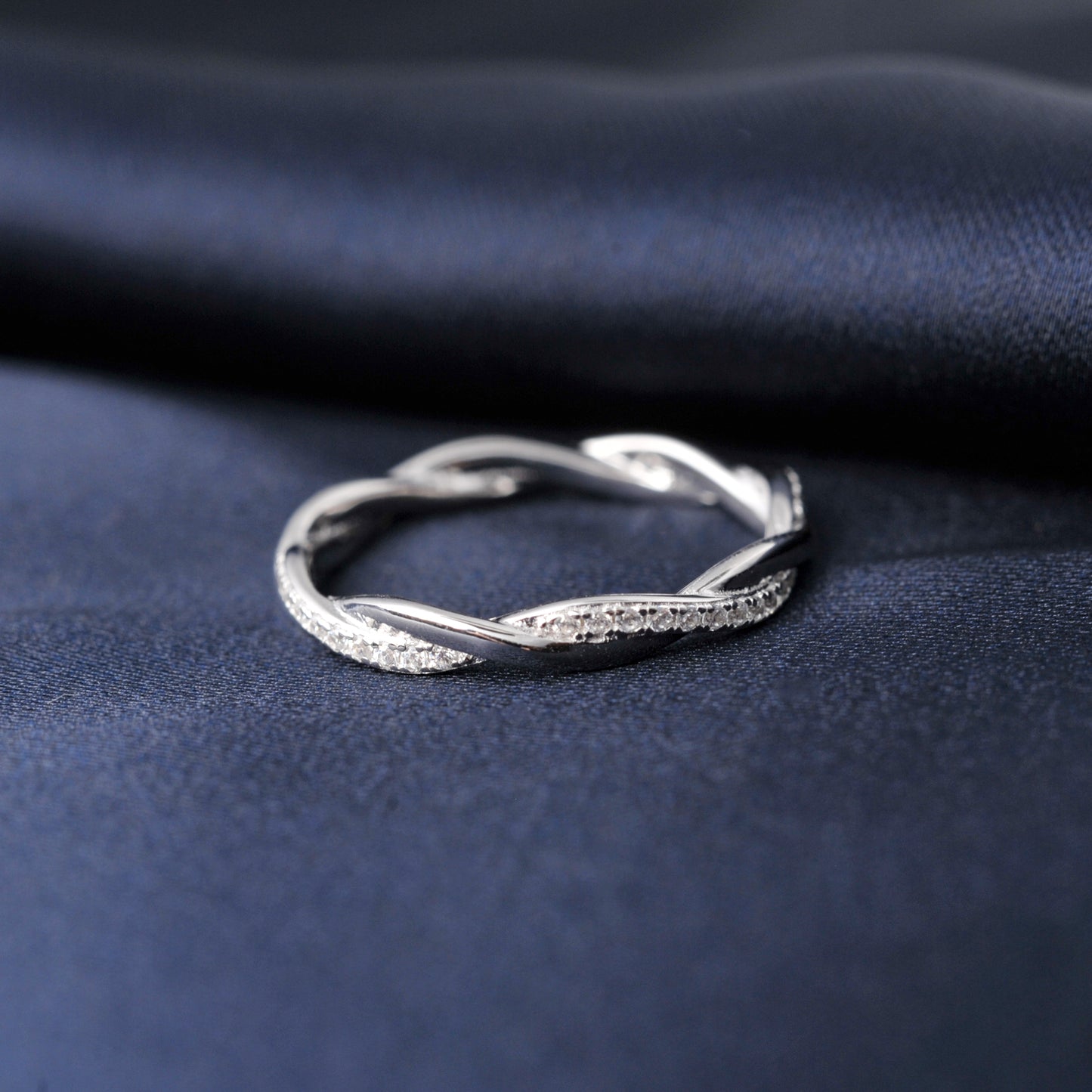 Luxury silver band ring featuring round-cut moissanite stones in an infinity design.
