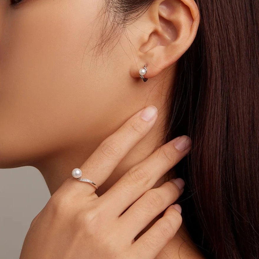 Woman wearing the Pearl Elegance Silver Ring paired with matching earrings for a coordinated and sophisticated look