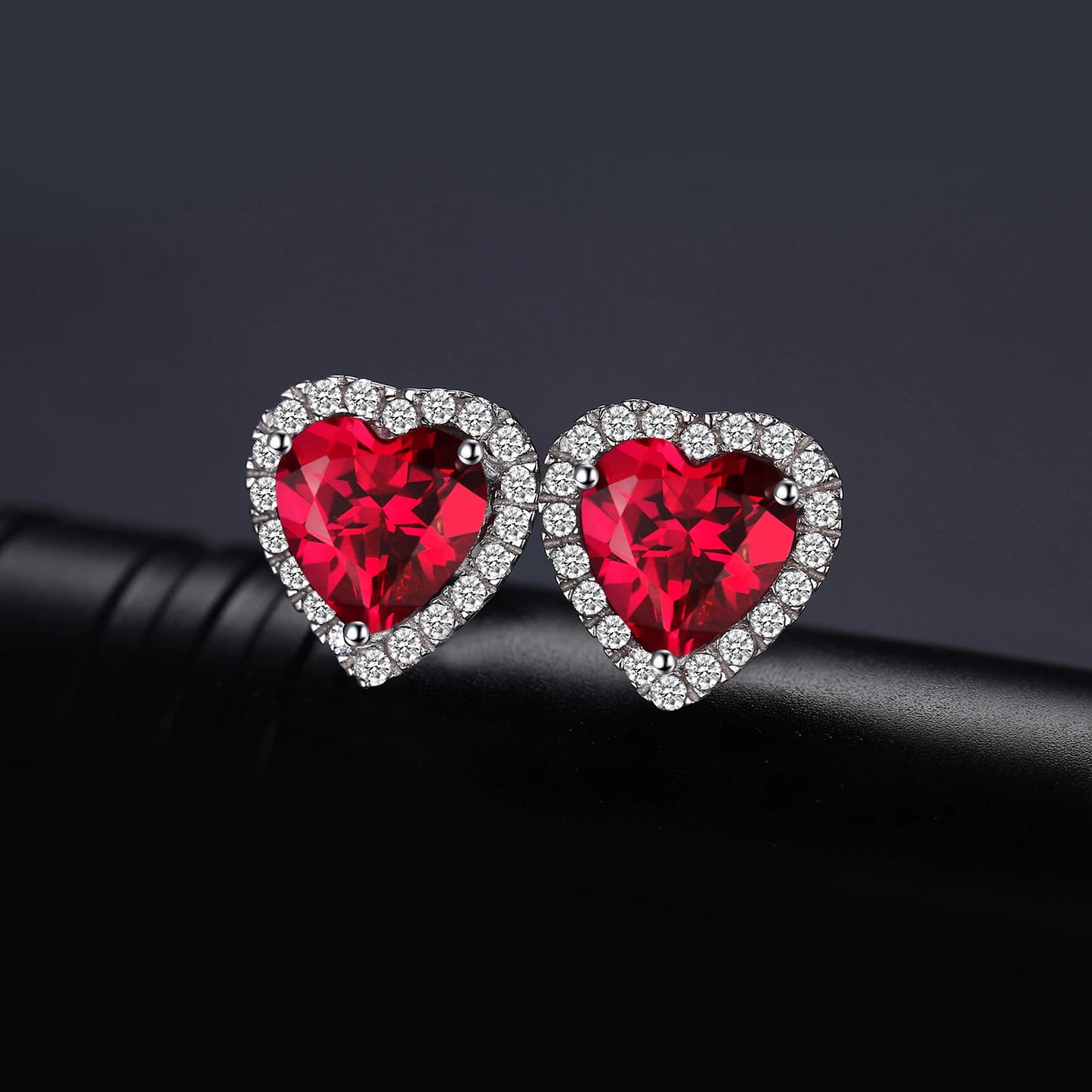 Ruby Love Silver Earrings displayed on black background for a luxurious presentation.