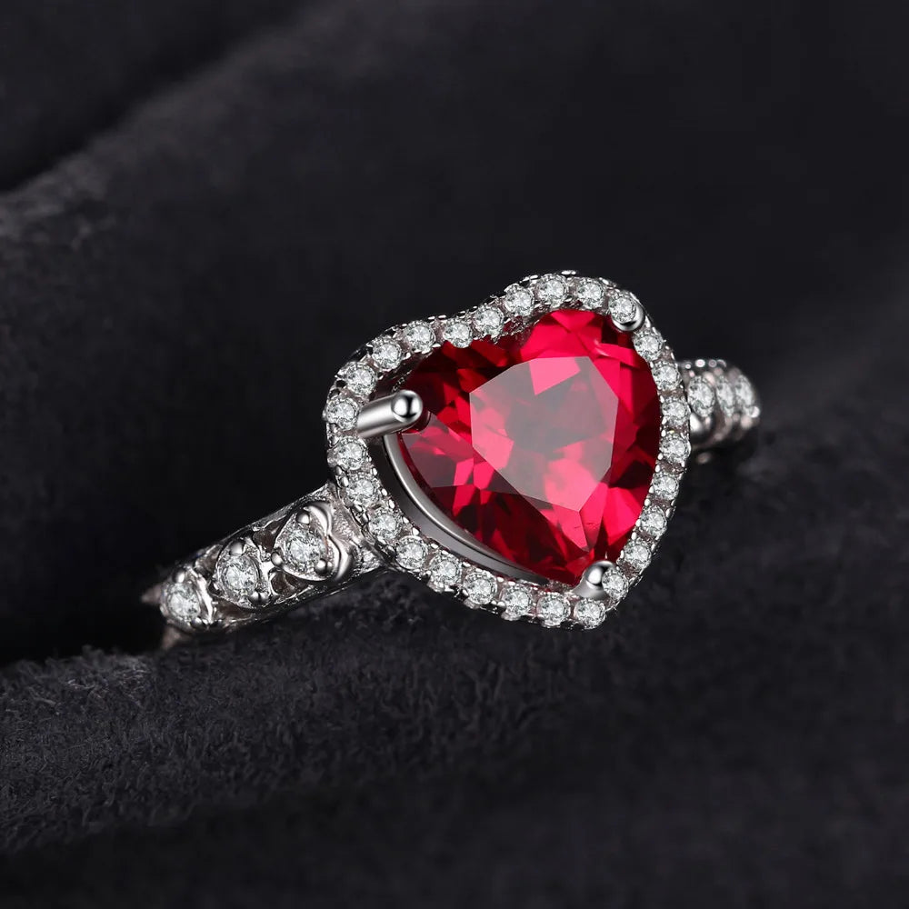 Ruby Love Silver Ring displayed on soft black fabric, emphasizing the deep red heart-shaped ruby and elegant silver setting.