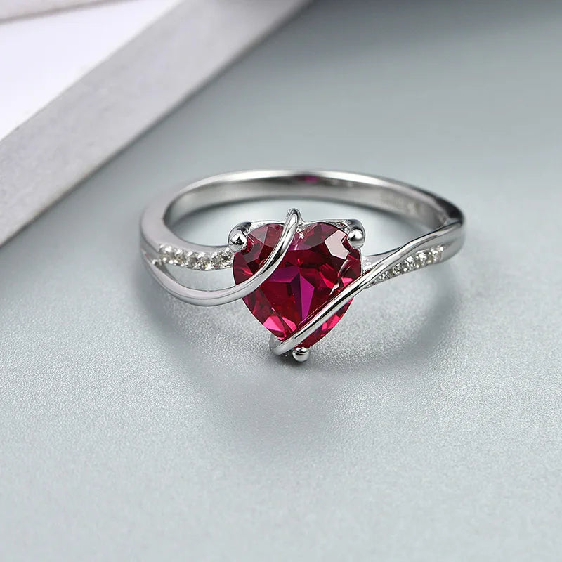 Sophisticated silver ring with a heart ruby stone and shimmering side stones.