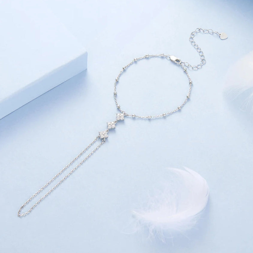 Silver bracelet with star-shaped charms on a light blue background