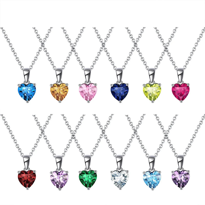 Full collection of 12 silver heart birthstone necklaces arranged in a row, each featuring a colorful cubic zirconia stone.