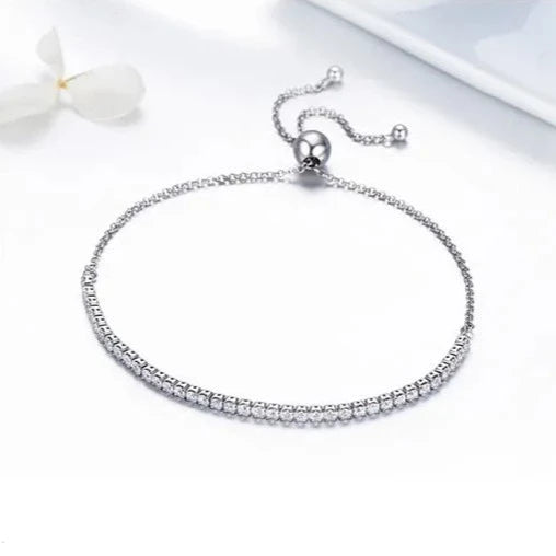 Elegant cubic zirconia tennis bracelet featuring a flexible silver design and sliding clasp.
