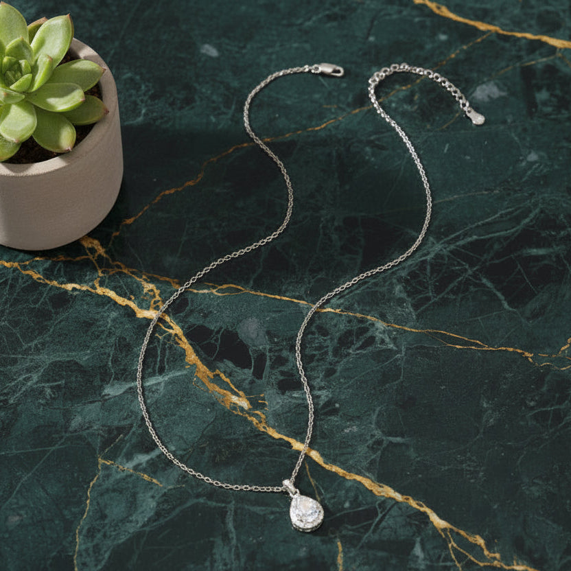 High-end macro shot of the Celeste Moissanite necklace on premium green marble for the Ava Modus collection