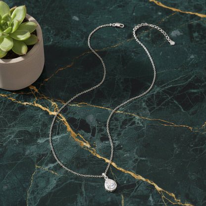 High-end macro shot of the Celeste Moissanite necklace on premium green marble for the Ava Modus collection