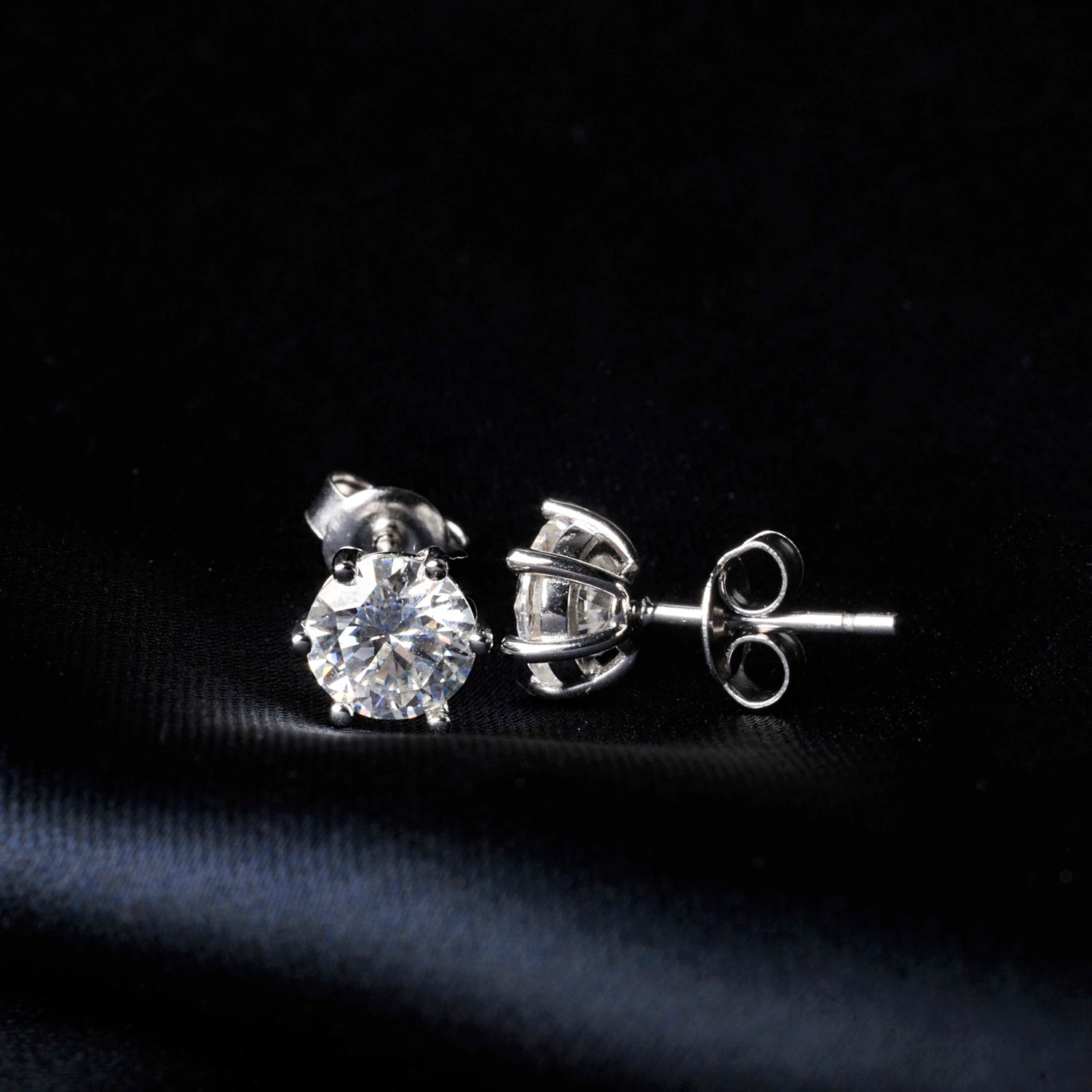 Moissanite stud earrings on a black background