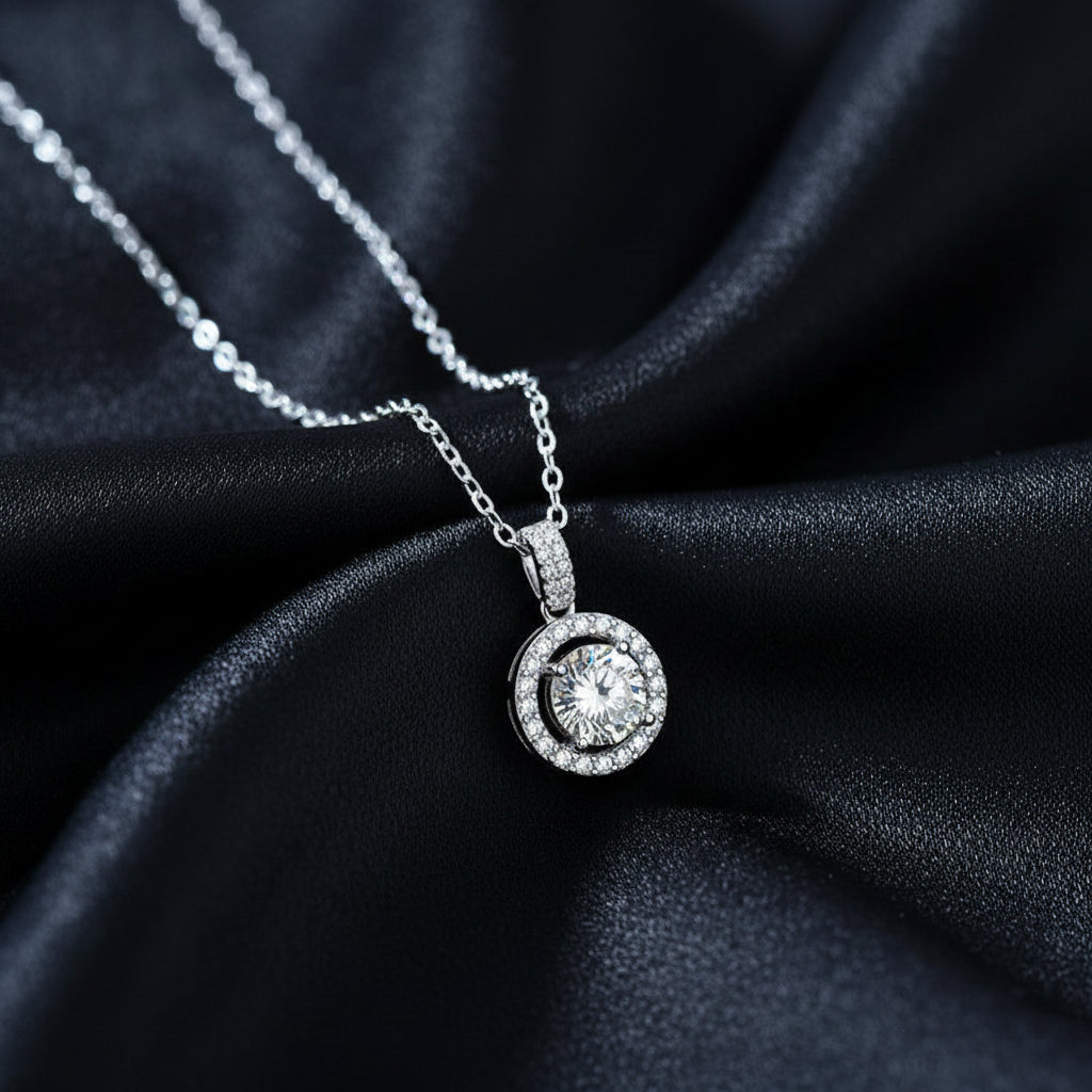 Ava Modus round Moissanite halo pendant displayed on draped black silk to showcase the rhodium finish