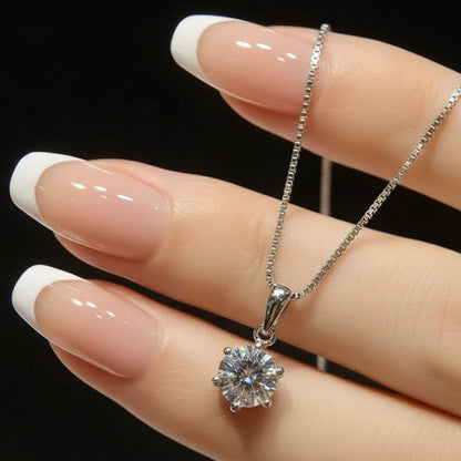 A close-up of the Celeste Solitaire Moissanite Necklace held in hand, showcasing the precision-cut D-VVS1 stone and premium silver finish
