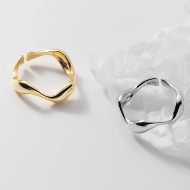 A pair of Golden Wave stackable rings in silver and gold-plated finishes, highlighting their minimalist and elegant wave design