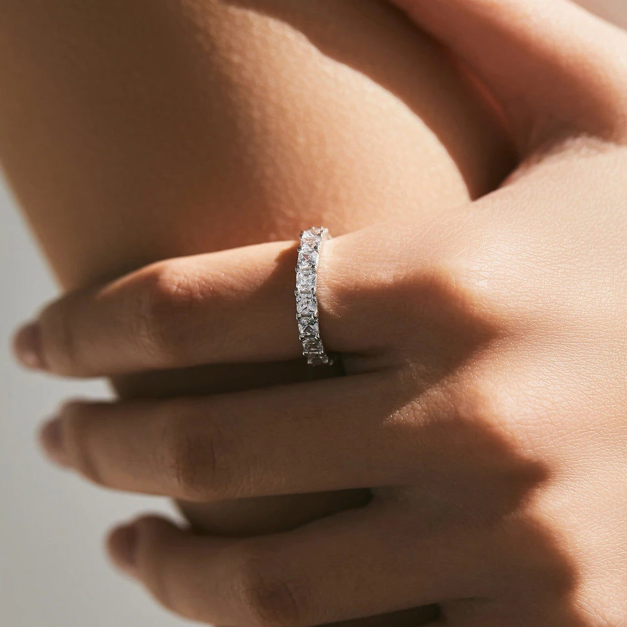 Luna bands worn in natural light to highlight sparkle of white cubic zirconia stones.
