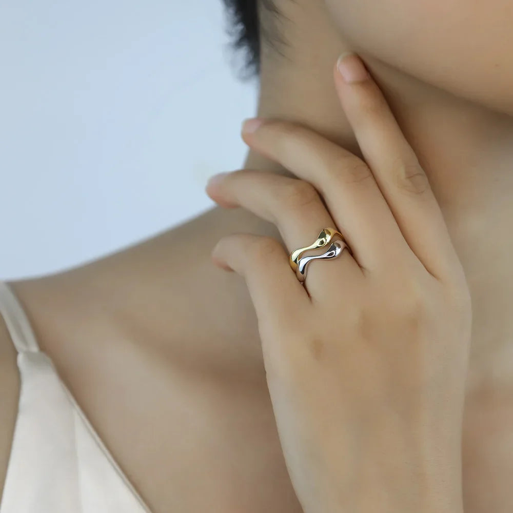 Model's hand featuring the silver and gold-plated Golden Wave Stackable Rings stacked together for an elegant and stylish appearance.
