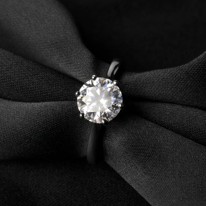 Moissanite ring on a black fabric background