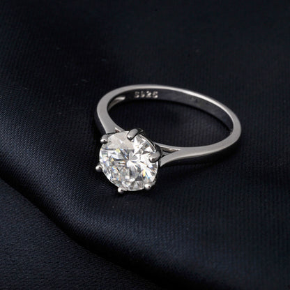 Silver ring with a large moissanite on a black fabric background