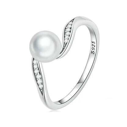 Close-up of pearl centerpiece surrounded by cubic zirconia on oxidized silver wave ring