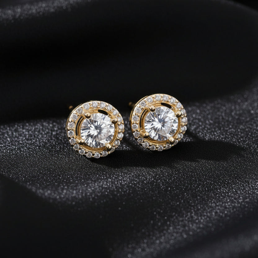 Close-up of the 18K gold-plated Pure Halo Studs against a dark silk background, showcasing the radiant embrace