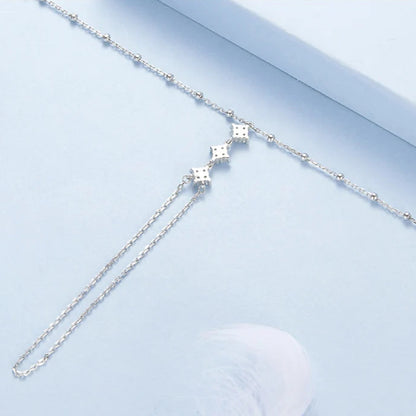 Silver hand chain bracelet on a light blue background