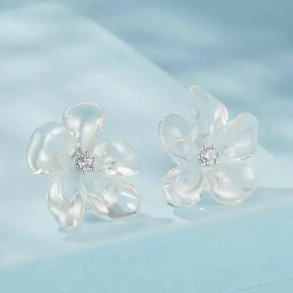 Delicate silver flower stud earrings, highlighting a textured floral shape with smooth edges